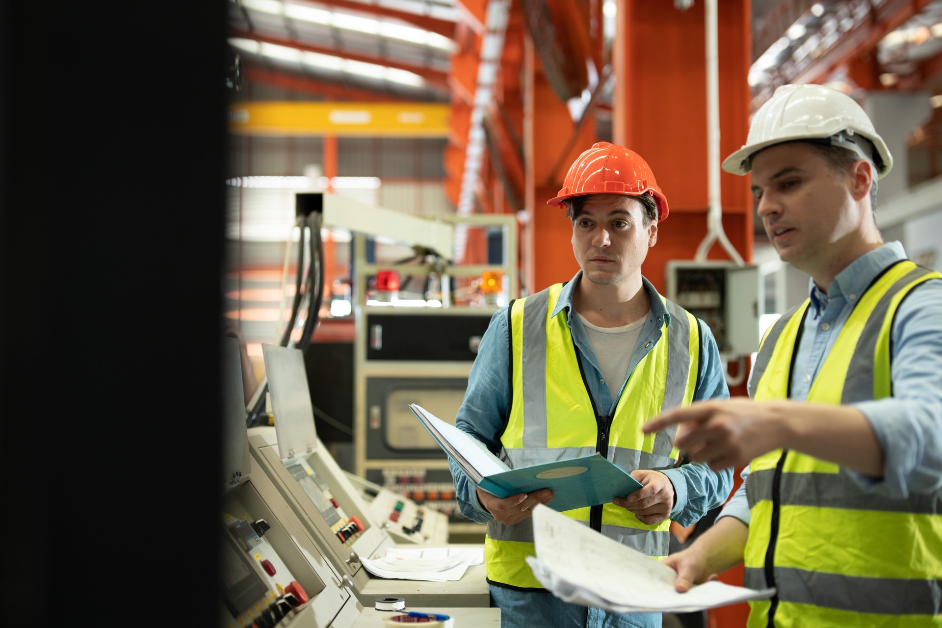 Two men engineer talking in modern factory. Production line machine and setting it for work.